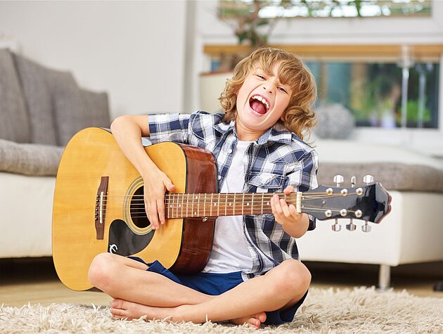 Junge der auf der Gitarre spielt und singt.